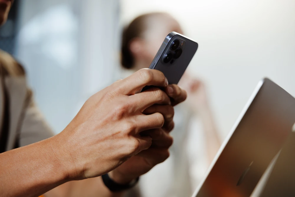 Man's hands typing on phone 
