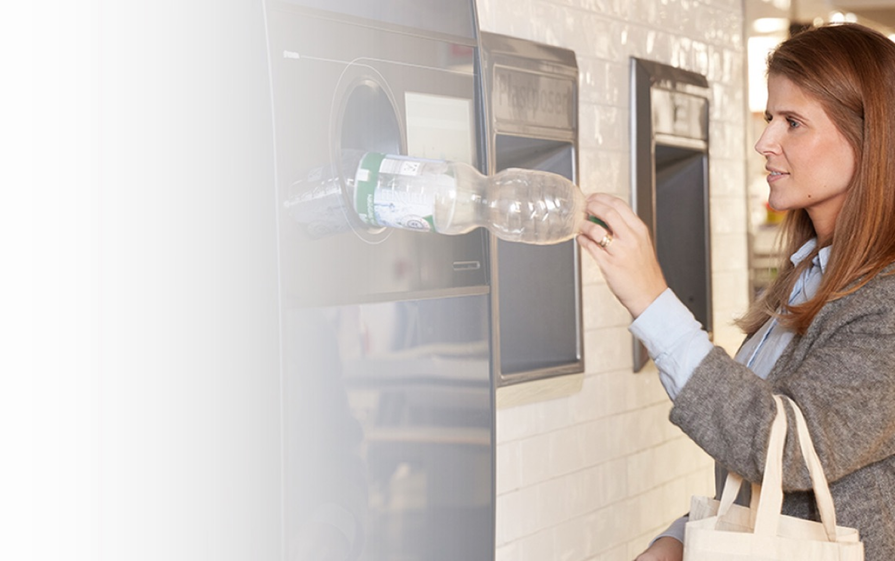 Woman recycling plastic bottle at reverse vending machine